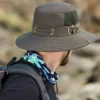 bob-chapeau-pour-les-hommes Un homme de dos porte un bob ficelle pour se protéger du soleil dans un décor de nature flouté