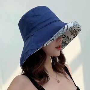 Une femme porte un bob chapeau élégant bleu marine sur un décor clair et lumineux