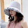 bob-chapeau-femme-gris Une femme porte un bob chapeau élégant gris sur un décor clair et lumineux