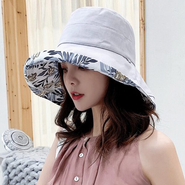 bob-chapeau-femme-gris Une femme porte un bob chapeau élégant gris sur un décor clair et lumineux