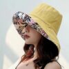 bob-chapeau-femme-jaune Une femme porte un bob chapeau élégant jaune sur un décor clair et lumineux