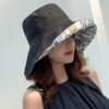 bob-chapeau-femme-noir Une femme porte un bob chapeau élégant noir sur un décor clair et lumineux