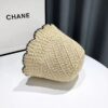 bob-chapeau-pour-la-plage-en-paille Un bob en paille couleur beige renversé sur le côté posé sur une table blanche