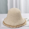 Un bob au crochet beige clair avec des franges sur un décor clair