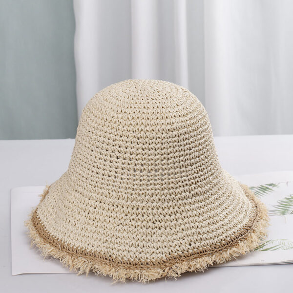 Un bob au crochet beige clair avec des franges sur un décor clair