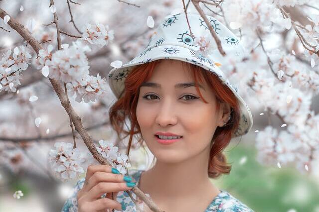 Ravissante-femme-porte-bob-chapeau-au-printemps-lorsque-les-arbres-sont-en-fleur