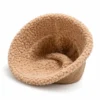 bob-chapeau-laine-interieur-doublure-fourrure-homme Un bob chapeau avec un intérieur en laine de mouton est retourné sur un décor blanc