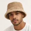 bob-hiver-homme Un homme porte un bob hiver beige sur fond blanc