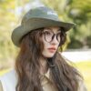 Fille avec lunettes et bob sur la tête prend la pose