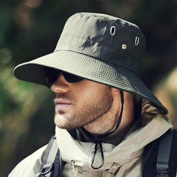 bob-safari-homme-vert Un homme porte un bob safari vert armée avec des lunettes de soleil en plein air