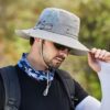 chapeau-bob-peche Un modèle de profil avec des lunettes noires de soleil porte un joli chapeau bob pêche gris clair sur la tête sur un décor de nature flouté
