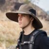 Un homme en pleine nature porte un large bob chapeau safari vert armée