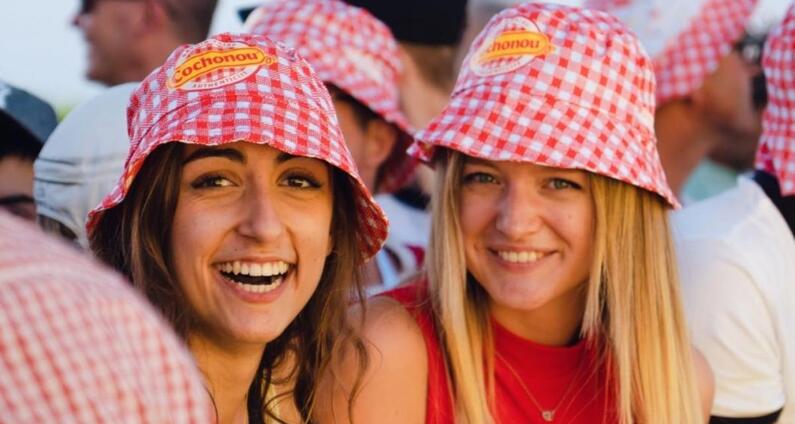 2-copines-souriantes-portent-un-bob-cochonou-et-font-la-fête