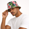 bob-fleuri-homme Un mannequin porte un bob chapeau fleuri et prend une pose sur fond clair