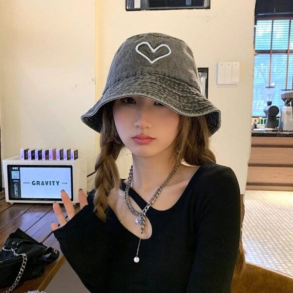 Jeune femme prend la pose avec son bob chapeau en jean sur la tête 2