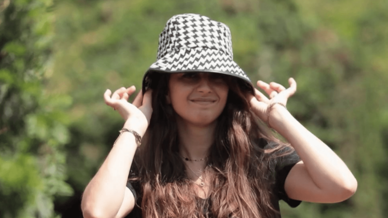 Une femme souriante montre son jolie bob chapeau