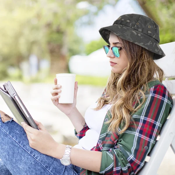 bob-ficelle-bonnie-militaire Jeune femme lit un livre au soleil et porte un bob avec ficelle boonie sur sa tête