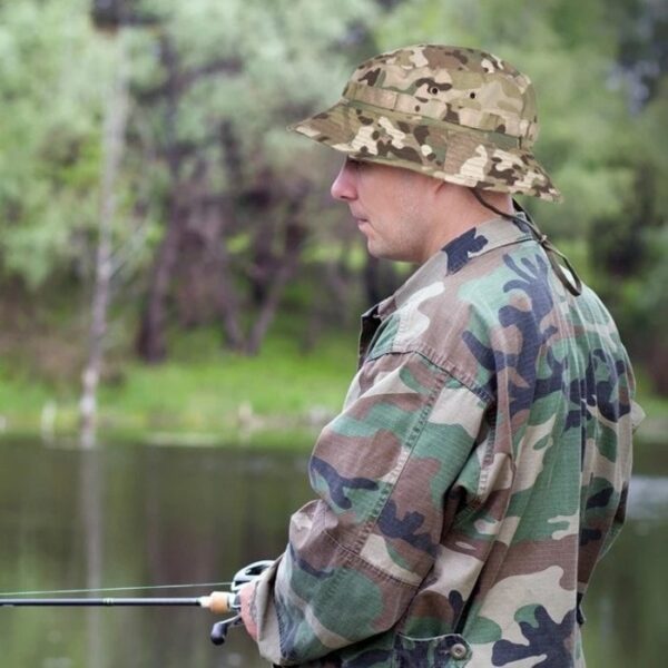 bob-ficelle-boonie Homme habillé en militaire est en train de pêcher et porte un bob ficelle boonie sur la tête