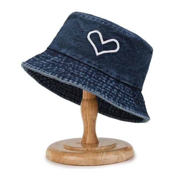 Bob en jean bleu marine avec un dessin de cœur présenté sur un support à chapeau en bois