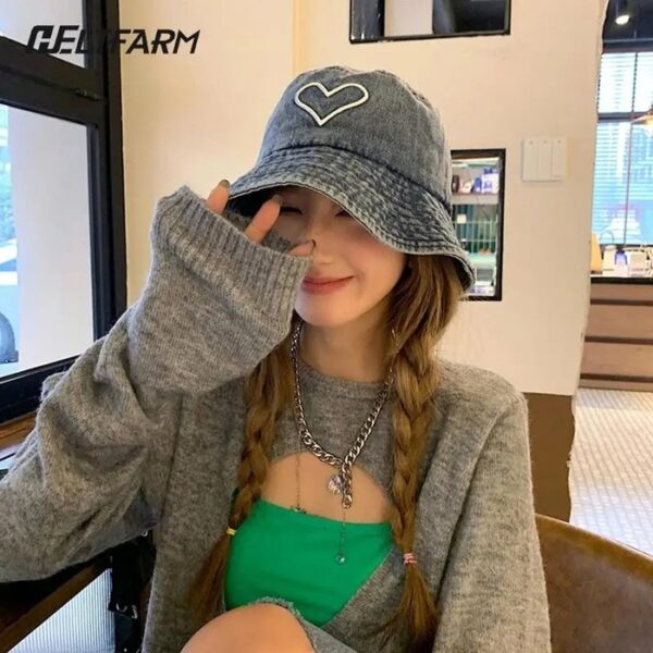 Jeune femme prend la pose avec son bob chapeau en jean sur la tête 1