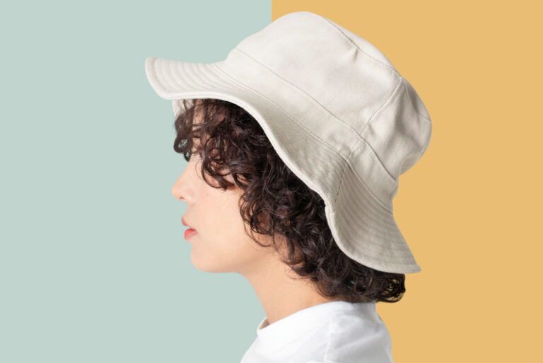 Homme porte un bob chapeau blanc lavé et bien propre sur fond coloré jaune et bleu