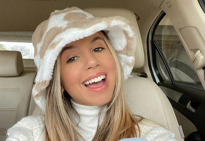 Jeune femme souriante en hiver se protège du froid avec un gros bob chapeau en fourrure bien épais