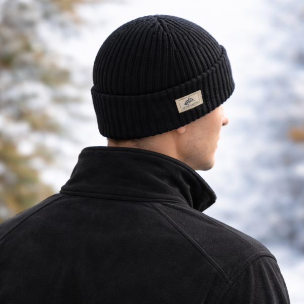 bonnet-cagoule-chaud-hiver Un modèle de dos porte un bonnet cagoule 2 en 1 en laine noir