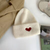 bonnet-cœur-blanc Un bonnet cœur couleur blanc est présenté posé à plat