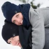Couple heureux portent un bonnet sur la tête dans un paysage enneigé