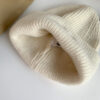 bonnet-hiver-epais-chaud-blanc Un bonnet est présenté avec vue sur son intérieur chaud et confortable
