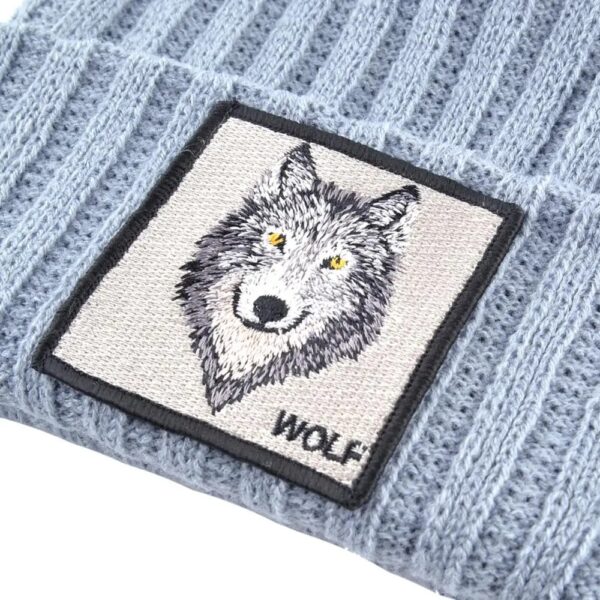 Une étiquette avec la tête d'un loup est cousue sur un bonnet gris