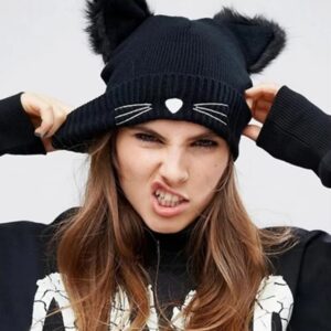 Une fille stylée porte un bonnet avec des oreilles sur fond gris