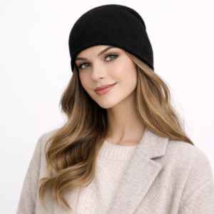 bonnet-en-cachemire Une femme porte un bonnet en cachemire noir sur un fond clair