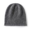 Un bonnet en cachemire de couleur grise est présenté à plat sur un fond blanc