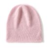 Un bonnet en cachemire de couleur rose est présenté à plat sur un fond blanc