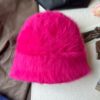 Un bonnet fourrure femme rose rouge est présenté sur un décor doux