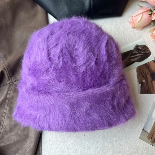 Un bonnet fourrure femme violet est présenté sur un décor doux
