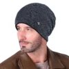 Un modèle porte un bonnet bleu doublé en polaire sur fond blanc