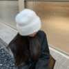 Une femme porte un bonnet doux en fourrure, vue de dessus du chapeau