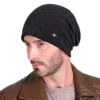 Un modèle porte un bonnet noir doublé en polaire sur fond blanc