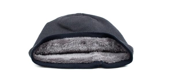 Un bonnet est présenté à plat et on voit sa doublure intérieure en polaire sur un fond blanc