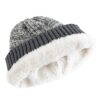 Un bonnet épais en laine gris est montré à plat sur fond blanc et on voit son intérieur double en polaire blanc et chaud