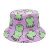Un bob avec des motifs ludiques et pastels et des grenouilles imprimées est présenté sur un fond blanc