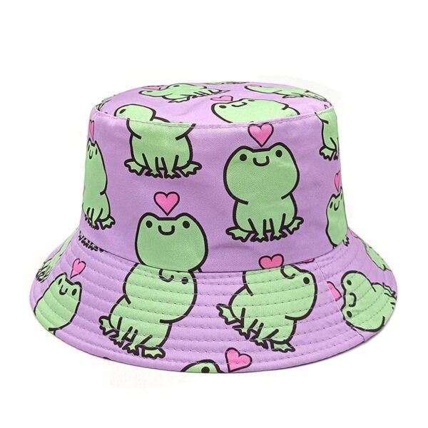 Un bob avec des motifs ludiques et pastels et des grenouilles imprimées est présenté sur un fond blanc