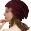 bonnet-femme-couleur-bordeaux Une femme porte un bonnet bordeaux sur un décor blanc