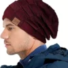bonnet-pour-hommes-couleur-bordeaux Un homme porte un bonnet bordeaux sur un décor blanc