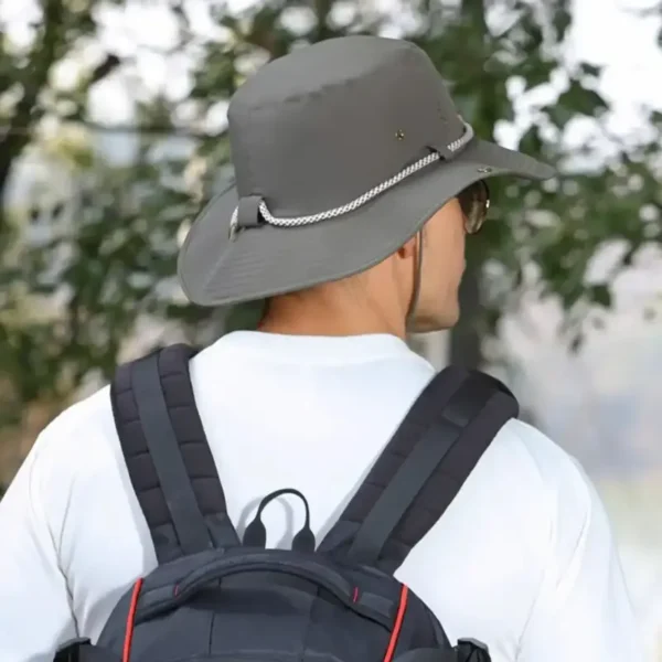 S6de8669ea7fa4c7ea2d78b083bb86e7 (1) Un homme style aventurier de dos porte un bob randonnée couleur vert armée sur la tête dans un décor de nature