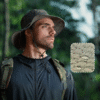 bob-randonnee-homme-etanche-resistant-pluie Un aventurier porte un chapeau de pêcheur résistant à la pluie couleur vert sur la tête dans un décor de nature