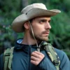 homme-portant-un-chapeau-aventurier-pour-la-randonnee Un aventurier porte un chapeau avec ficelle dans une jungle