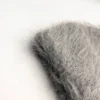 bonnet-gris-texture-duveteuse-grosse-maille Gros plan sur un bonnet en alpaga gris avec une texture duveteuse et poils longs, photographié sur fond blanc pour montrer la matière douce et chaude.